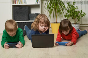crianças de geração alpha brincando em eletrônicos