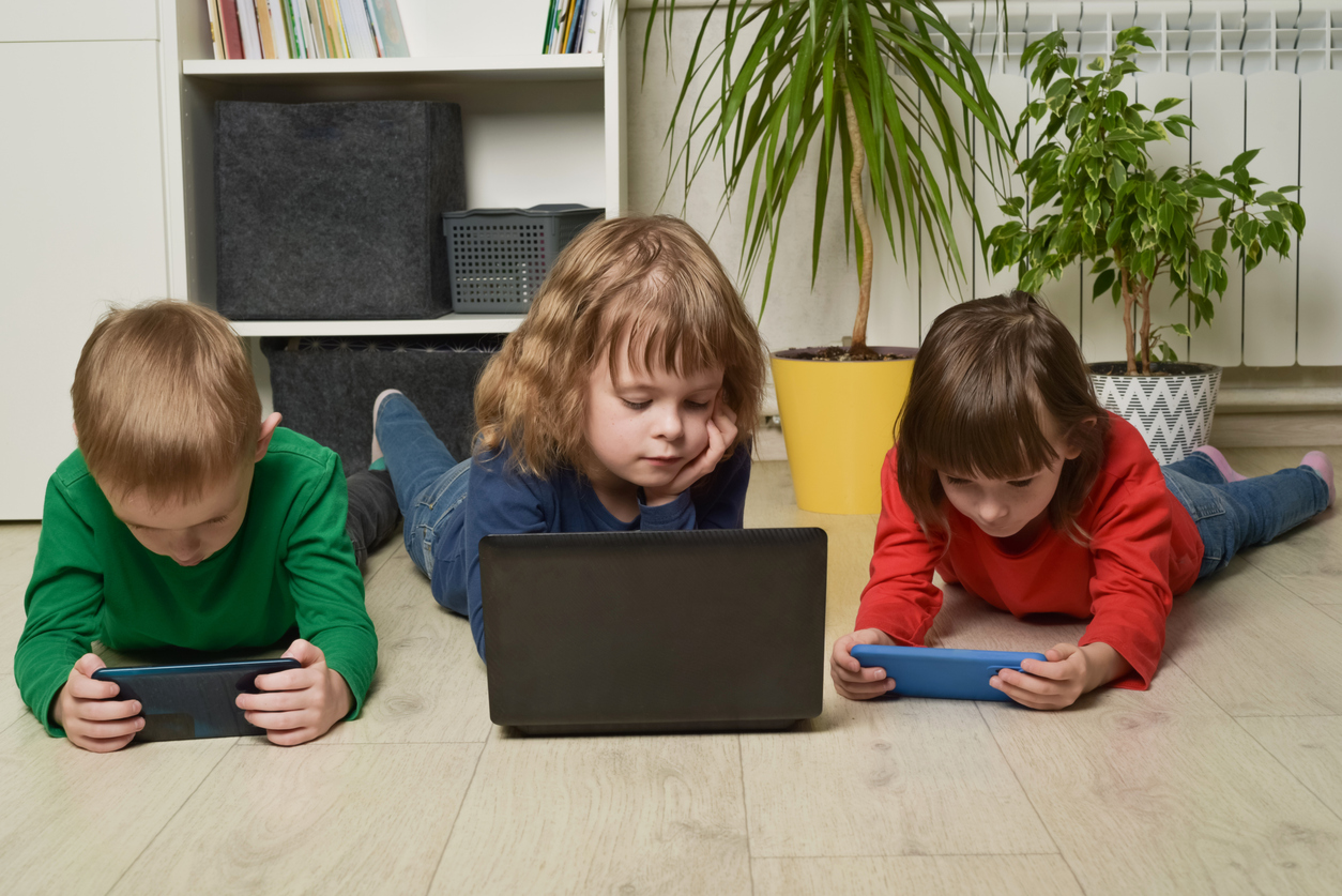 crianças de geração alpha brincando em eletrônicos